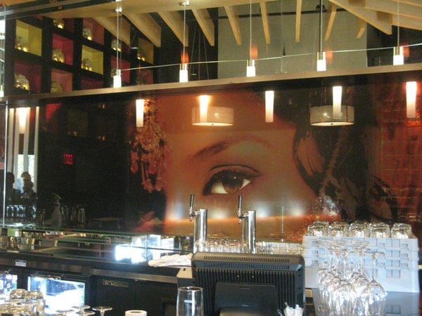 dark colored window graphics of woman with eye in bar