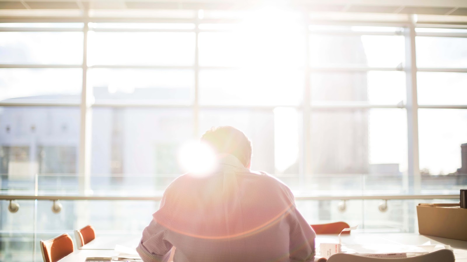 man sitting at a table in front of a window